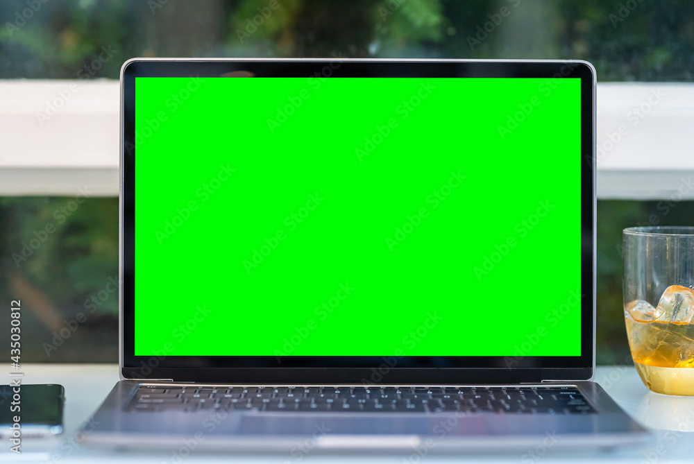 Mockup of laptop computer with empty screen with coffee cup and smartphone on table of the coffee shop background,Green screen Mockup of laptop computer with empty screen with coffee cup and smartphone on table of the coffee shop background,Green screen