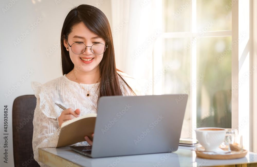 Happy of asian freelance people Businesswoman Taking written Notes to on notebook casual working with laptop computer with a coffee cup mug and smartphone at the cafe,Business Lifestyle Happy of asian freelance people Businesswoman Taking written Notes to on notebook casual working with laptop computer with a coffee cup mug and smartphone at the cafe,Business Lifestyle
