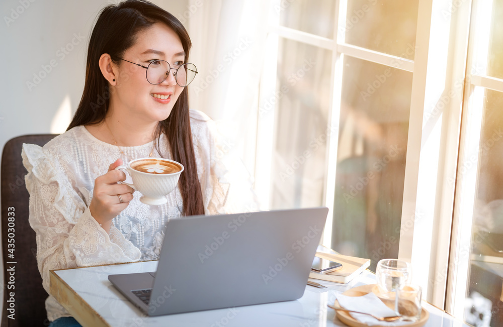Happy of asian freelance people businessfemale hold a coffee cup mug casual working with laptop computer with Notebook and smartphone in coffee shop,Business Lifestyle communication concept Happy of asian freelance people businessfemale hold a coffee cup mug casual working with laptop computer with Notebook and smartphone in coffee shop,Business Lifestyle communication concept