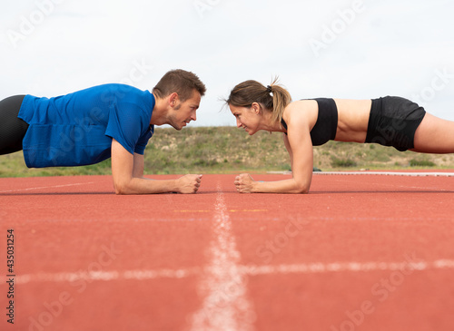 Sporty couple exercising on outdoor running track