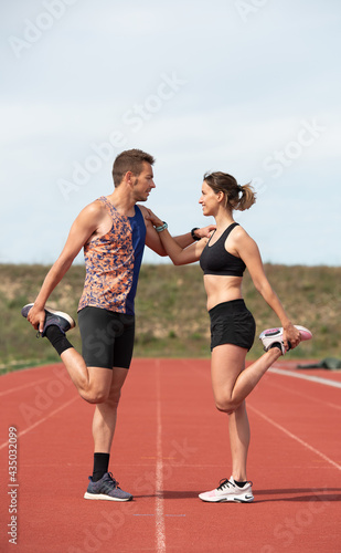 Sporty couple exercising on outdoor running track