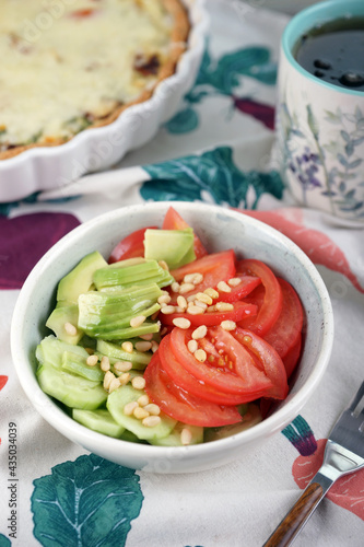 Vegetable salad with tomatoes, cucumbers, avocado and pine nuts