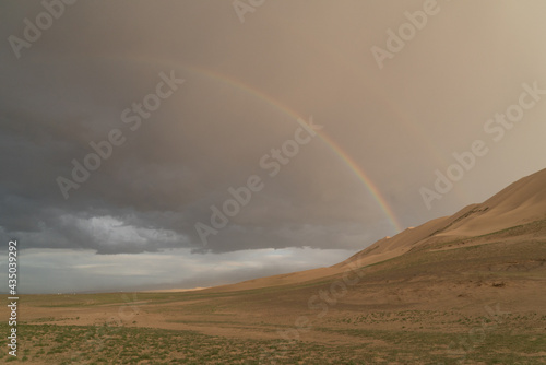 rainbow over dunes in the gobi desert in mongolia
