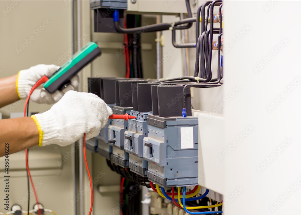 Electrical engineer tests the operation of the electric control cabinet on a regular basis for maintenance. Electrical engineer tests the operation of the electric control cabinet on a regular basis for maintenance.