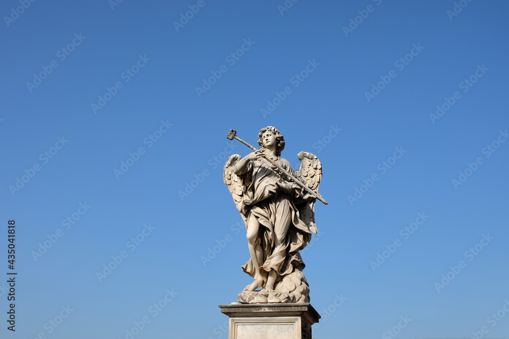 Φωτογραφία marble sculpture of an angel holding a hammer with the blue sky in the backgroun