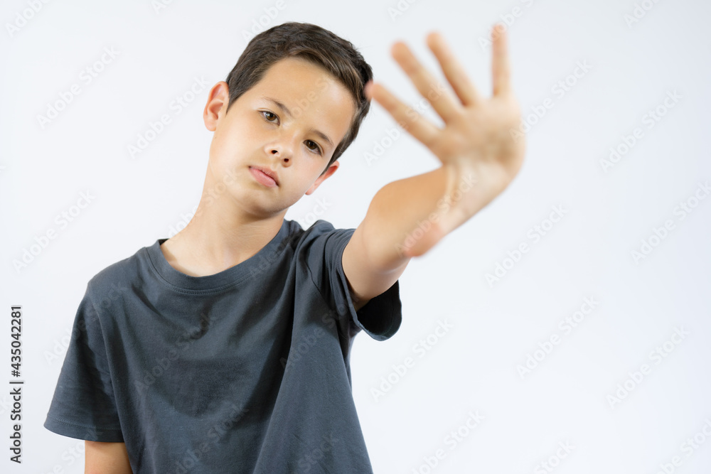 portrait of young boy doing stop symbol over white background portrait of young boy doing stop symbol over white background
