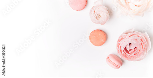 close-up view of pink and white macaroons, beautiful tender roses on a light background with copy space, selective focus 