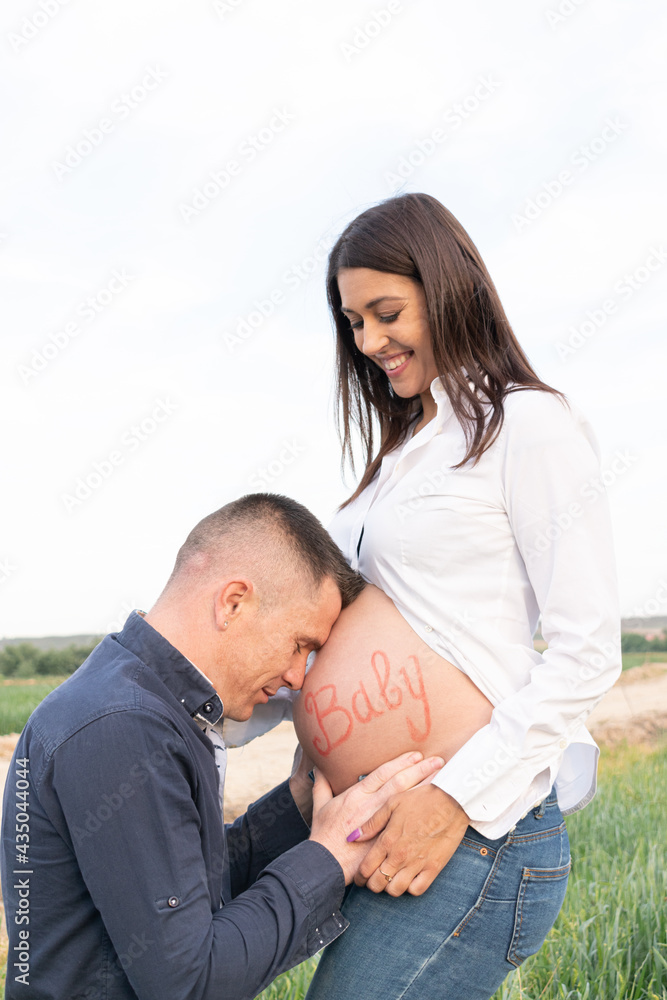 couple in love with the pregnant girl and the girl giving affection to the belly of their baby couple in love with the pregnant girl and the girl giving affection to the belly of their baby