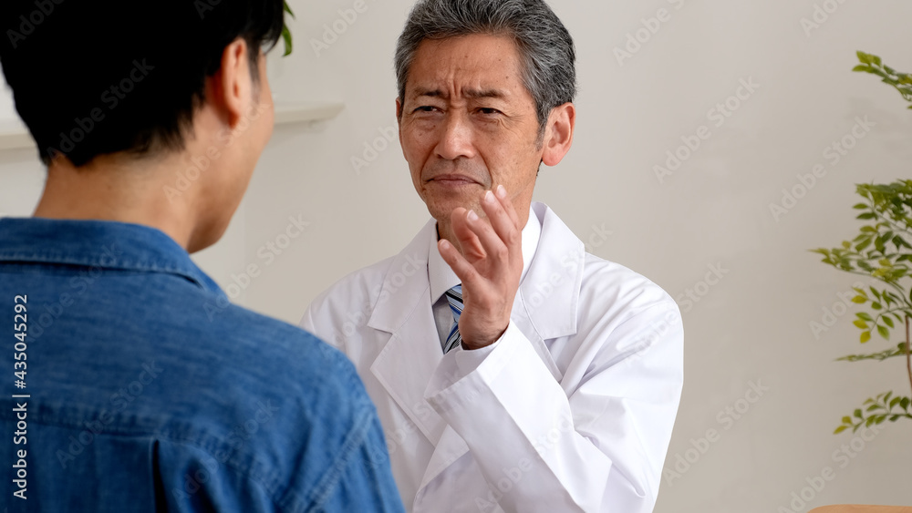 Obraz premium 真剣な表情で患者を説得するシニア医師
