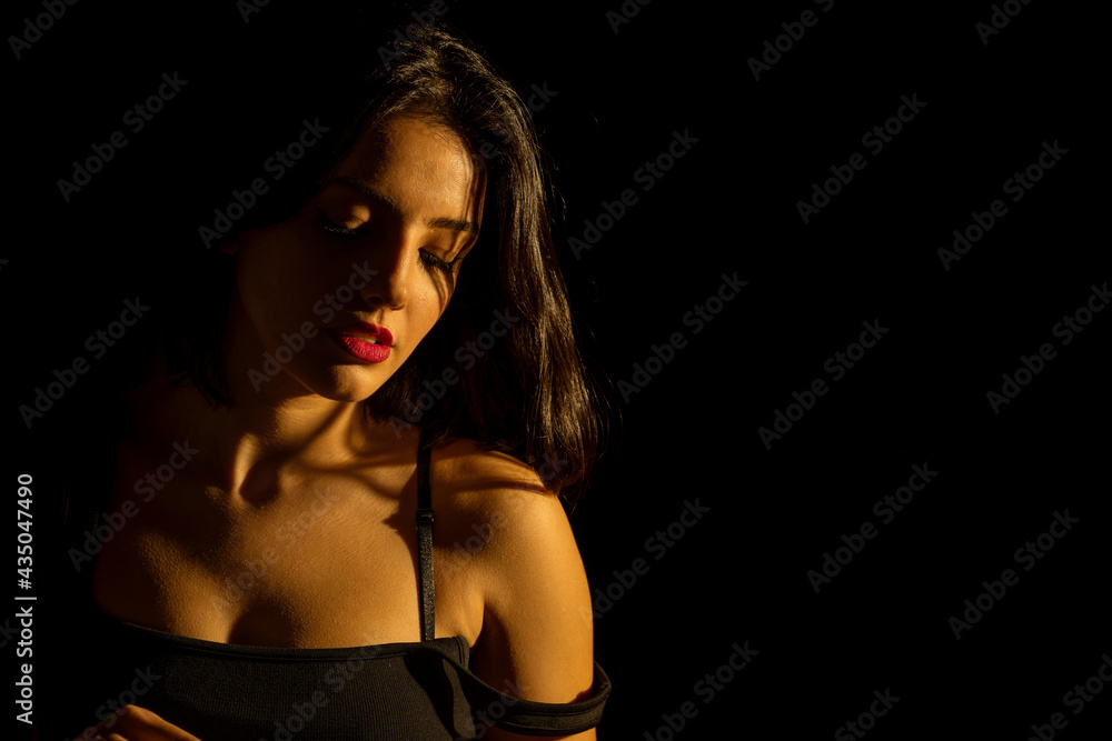 Portrait of attractive a young woman with cinematic lighting. Woman wearing  a suspender bodysuit. Half naked sexy woman. Horizontal shot. Stock Photo