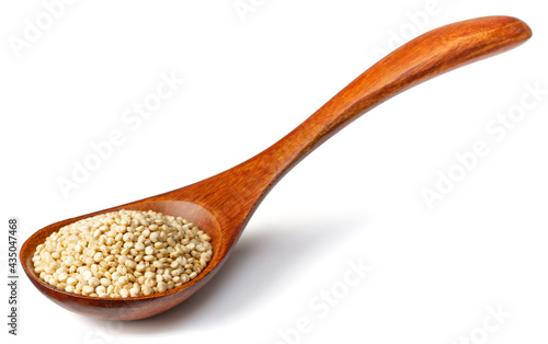 uncooked white quinoa in the wooden spoon, isolated on white background