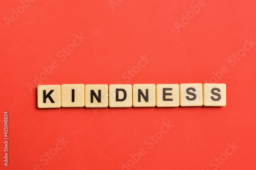 Top view of alphabet letters with text KINDNESS over red background. © TeacherPhoto