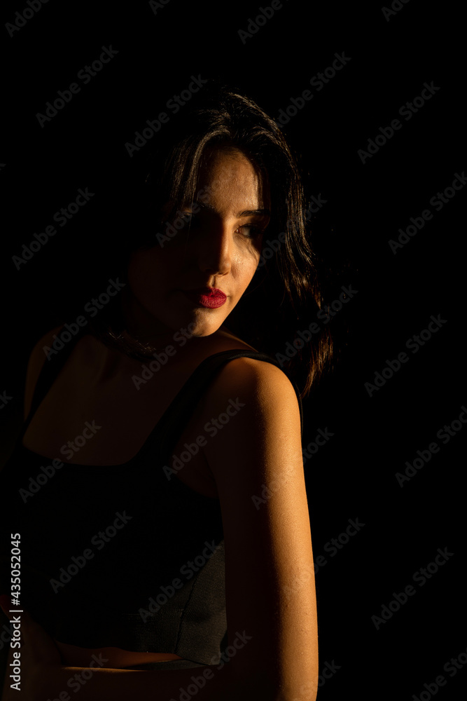 Portrait of attractive a young woman with cinematic lighting. Woman wearing a suspender bodysuit. Half naked sexy woman. Vertical shot. Portrait of attractive a young woman with cinematic lighting. Woman wearing a suspender bodysuit. Half naked sexy woman. Vertical shot.