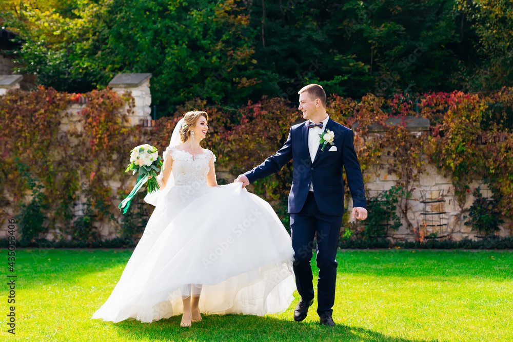 romantic couple after the ceremony is walking in the garden holding hands. romantic couple after the ceremony is walking in the garden holding hands.