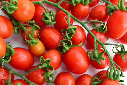 Background with red cherry tomatoes. Red tomatoes macro photo. Lots of red cherry tomatoes. Ripe red tomatoes close up vegetable background Top view blurry textures soft focus.
