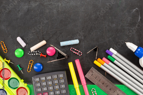 School supplies on blackboard background ready for your design.