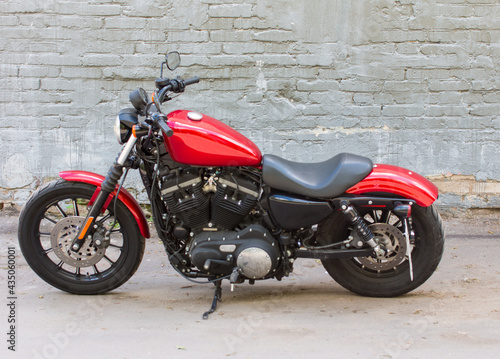 a red motorcycle near a brick wall. Parking near the building is a hipster urban hobby