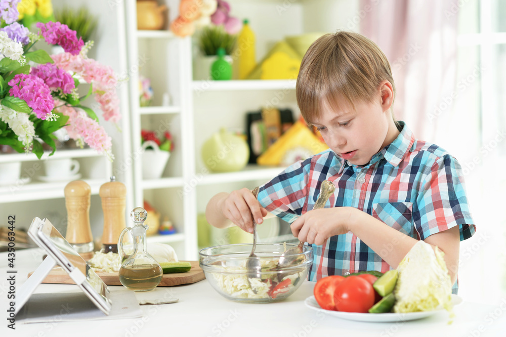 boy preparing delicious fresh salad in kitchen boy preparing delicious fresh salad in kitchen