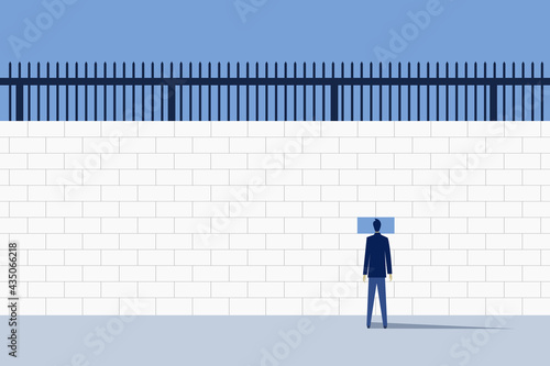 A man looking outside through a hole in a huge prison wall