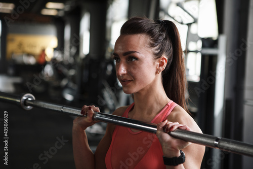 Close up of a sportswoman holding barbell, doing push press exercise