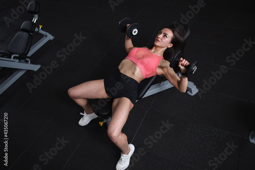 Top view shot of a female athlete doing bench press with weights