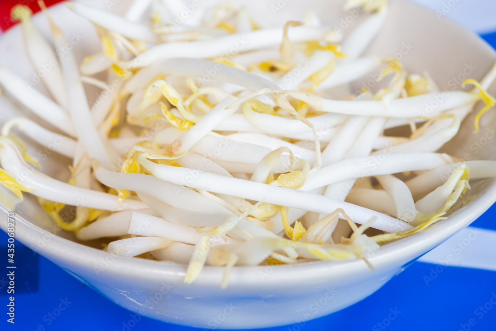 Close up of mungbean sprouts on blue table.