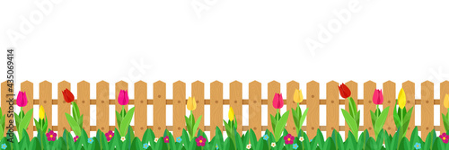 Flowers growing in front of wooden fence