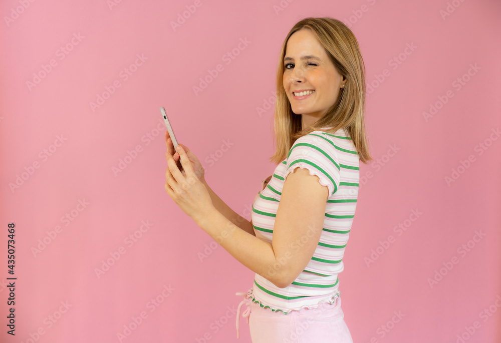 Profile side photo of cute lady looking into her device smiling searching news wearing casual clothes isolated over pink background Profile side photo of cute lady looking into her device smiling searching news wearing casual clothes isolated over pink background