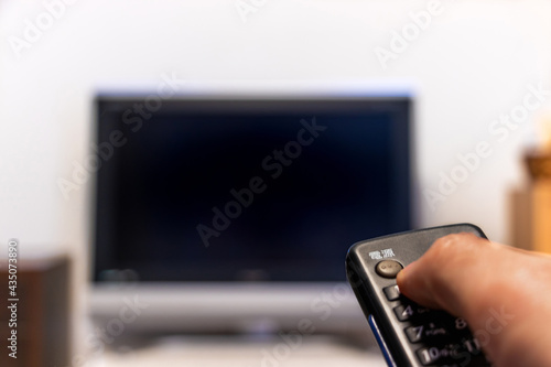 Bild auf Leinwand テレビのリモコンを操作する