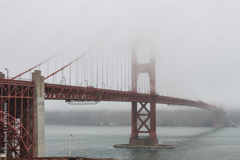 Obraz premium Golden Gate Bridge, San Francisco, USA-engineering masterpiece, art deco steel construction in orange with details such as lighting, outlining the cables and towers appearing out of the vanishing fog