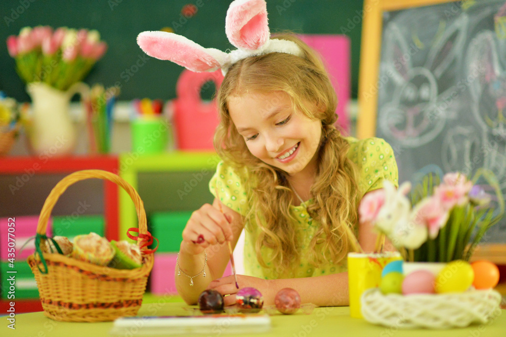 beautiful girl in bunny ears painting eggs for Easter holiday beautiful girl in bunny ears painting eggs for Easter holiday