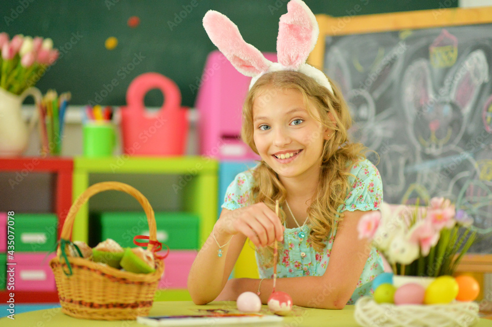 beautiful girl in bunny ears painting eggs for Easter holiday beautiful girl in bunny ears painting eggs for Easter holiday