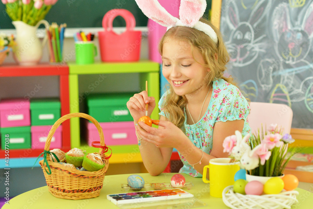 beautiful girl in bunny ears painting eggs for Easter holiday beautiful girl in bunny ears painting eggs for Easter holiday