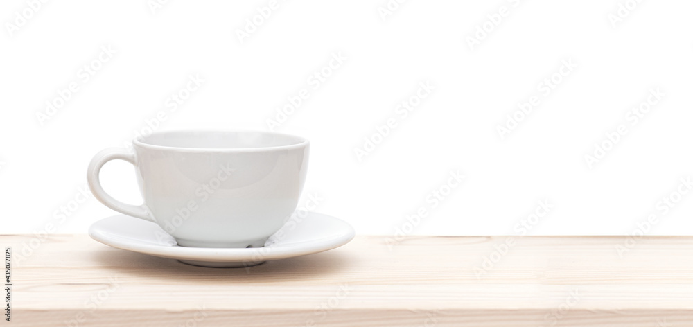 White ceramic cup or mug on wooden table in front of white background, space for text White ceramic cup or mug on wooden table in front of white background, space for text