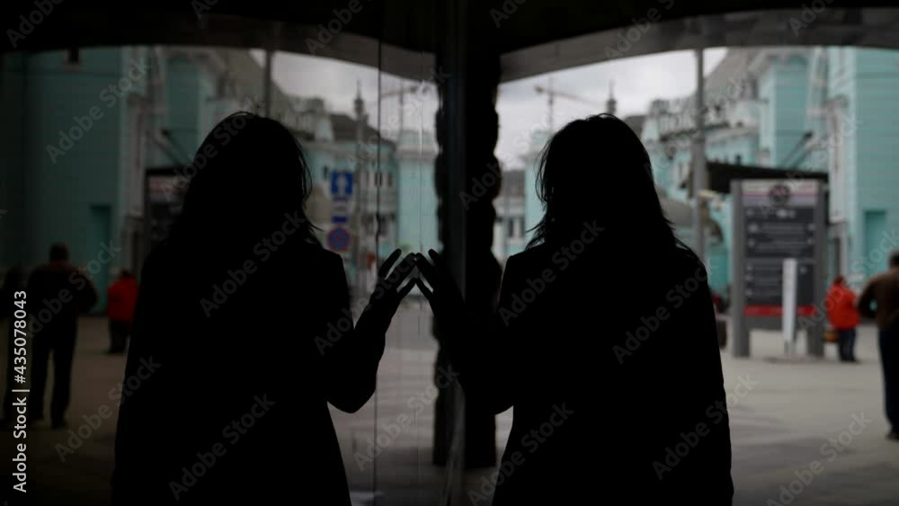 woman is walking in city, silhouette in dark lane, reflection of female body in mirror wall woman is walking in city, silhouette in dark lane, reflection of female body in mirror wall