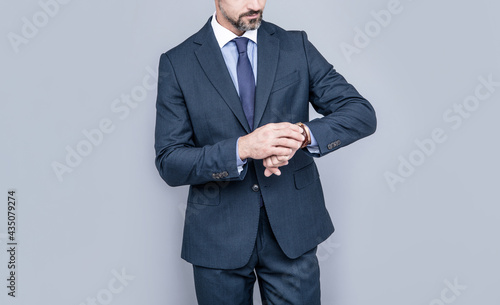 confident businessman man in businesslike suit watching time on wristwatch, time