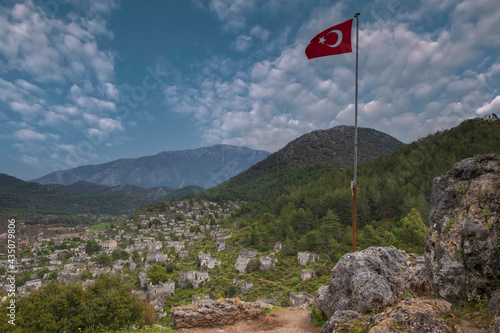 Abandoned Greek Village Kayakoy in Turkey with Turkish red flag
