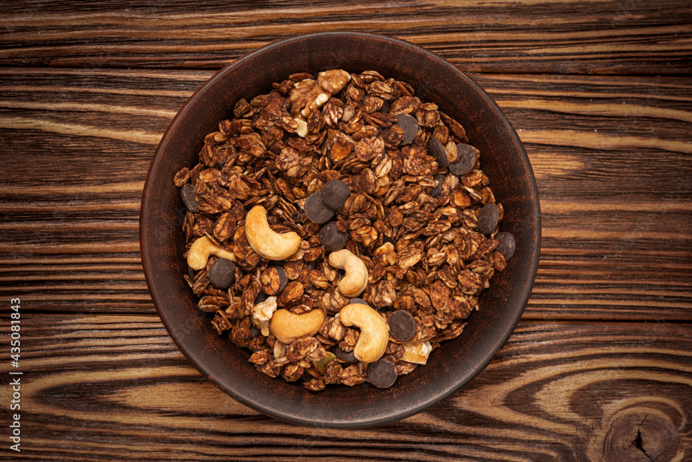 Chocolate granola cereal with nuts in a bowl. Chocolate granola cereal with nuts in a bowl.