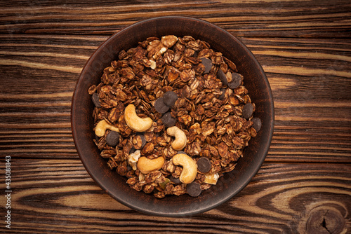 Chocolate granola cereal with nuts in a bowl.