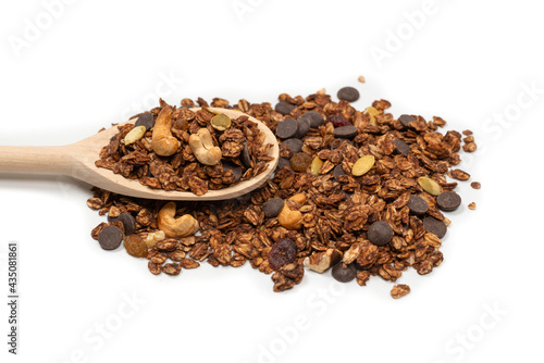 Chocolate granola cereal with nuts in a wooden spoon.