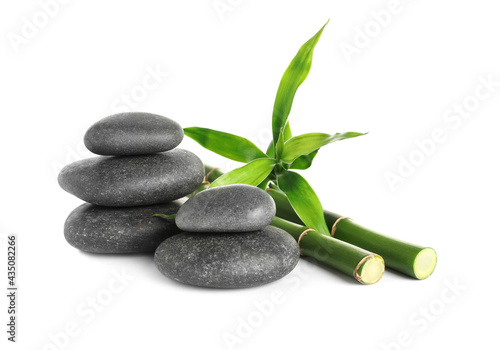 Spa stones and bamboo stems on white background