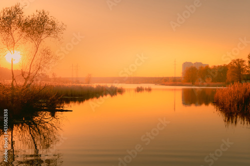 Foggy sunset over the lake near the city