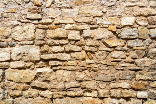 Yellow stone wall. Texture of a stone wall of an old house.