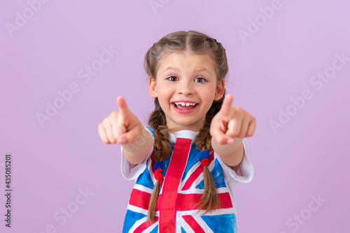 A teenage girl with an English flag points her fingers forward. photo