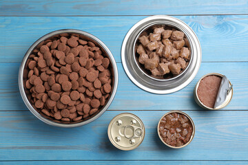 Wet and dry pet food on light blue wooden table, flat lay