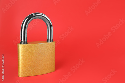 Modern padlock on red background. Space for text