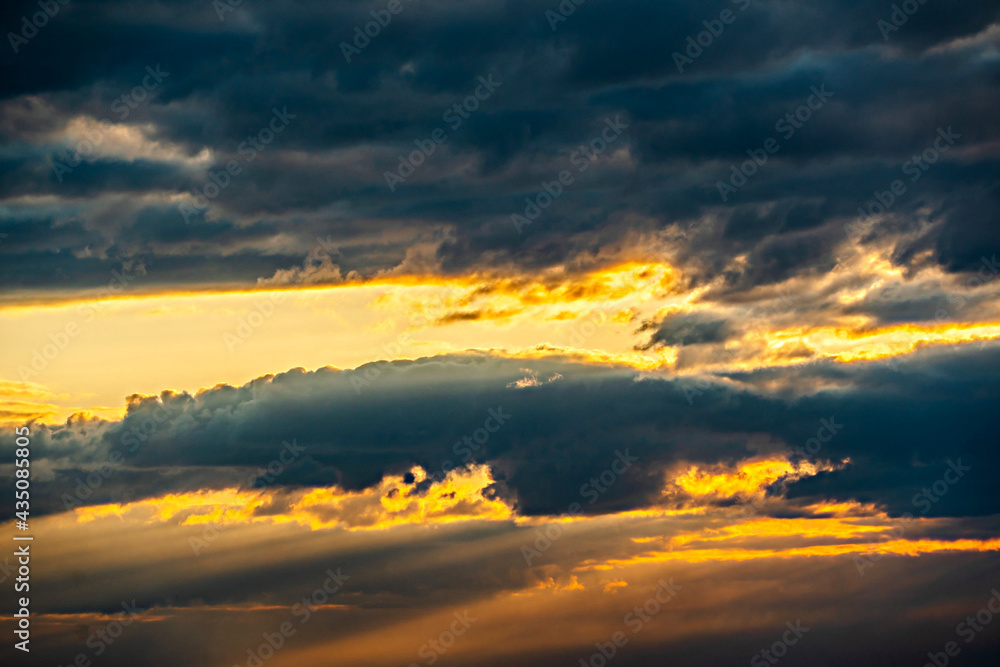 Fototapeta premium The heavenly light of the sun.Dramatic evening sky with clouds and rays of the sun.Sunlight at evening sunset or morning dawn.Panoramic view of the blue sky with clouds in motion.Heaven sunset