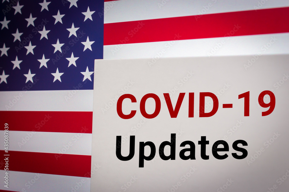 Conceptual keyword COVID-19 Updates on card on US flag background. Business, economy, social concept of America. National updated news about Coronavirus pandemic, disease and healthcare Conceptual keyword COVID-19 Updates on card on US flag background. Business, economy, social concept of America. National updated news about Coronavirus pandemic, disease and healthcare