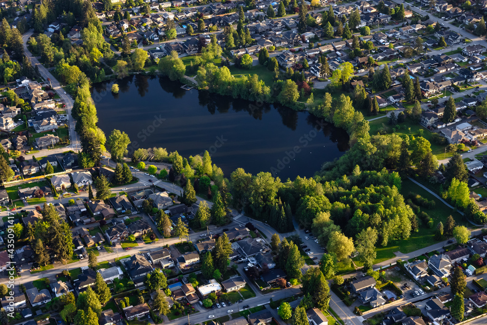 Aerial View from an Airplane of Residential Homes near a pond in Coquitlam, Greater Vancouver, British Columbia, Canada. Como Lake Park