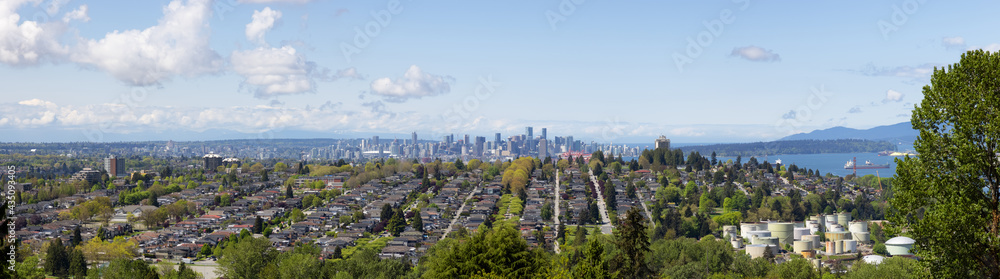 View of residential homes in suburban area of a modern city and Urban Downtown buildings in background. Vancouver, British Columbia, Canada.